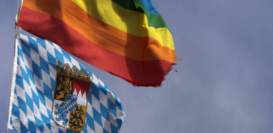 LGBT-Flagge über Bayernflagge an der Spitze eines Fahnenmasten