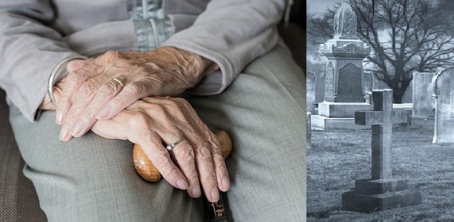 In the left part of the picture, an old lady with her hands crossed in her lap. In the right part, a gravestone.