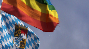 LGBT-Flagge über Bayernflagge an der Spitze eines Fahnenmasten