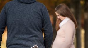 Ein Mann geht drohend auf eine schwangere Frau zu
